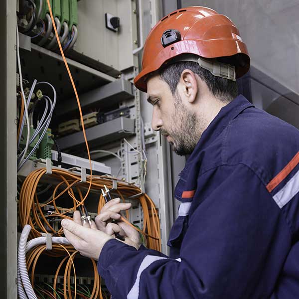 Engineer connecting Fiber Optic Cable to the Switch
